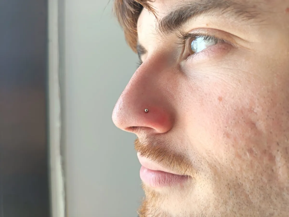 Piercing nostril con bola pequeña, de perfil, hecho en Santos Castelldefels