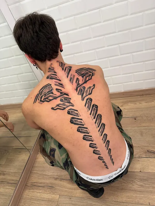 Tatuaje blackwork a lo largo de la columna, hecho en Santos Castelldefels